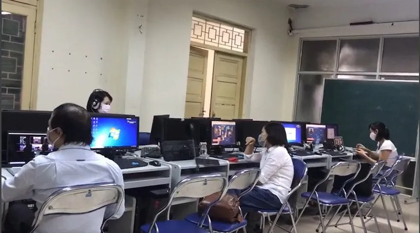 A group of people sitting at computersDescription automatically generated with low confidence